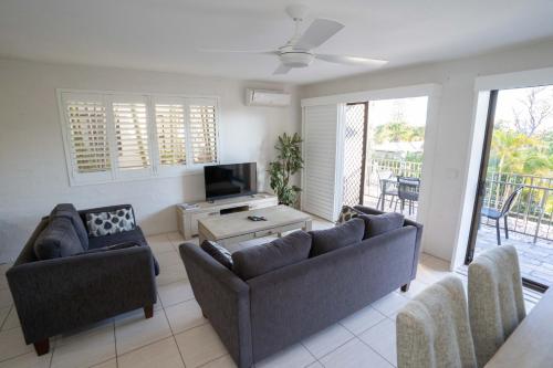 a living room with two couches and a television at Myuna Holiday Apartments in Noosa Heads