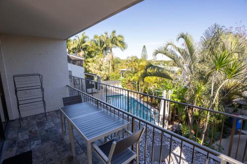 a balcony with a table and a view of a pool at Myuna Holiday Apartments in Noosa Heads