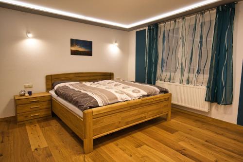 1 dormitorio con cama de madera y ventana en Ferienwohnung Erik, en Bad Staffelstein