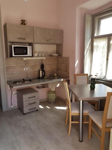 a kitchen with a table and a microwave at Kétbodonyi Apartments in Kétbodony