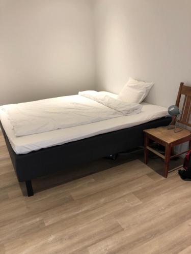 a bed with a black frame and white mattress at Soda Home - Karlsbo, 24 h check in in Närpiö