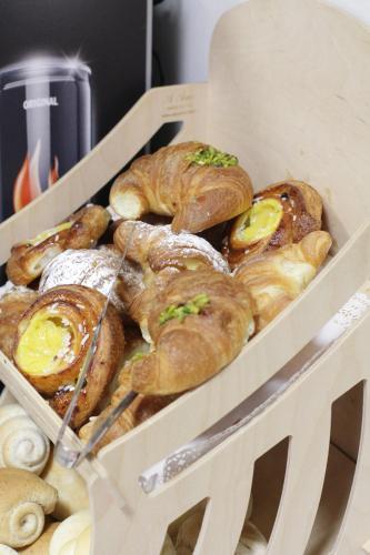 a box of croissants and pastries on a table at Hotel Croce Di Malta in Novara