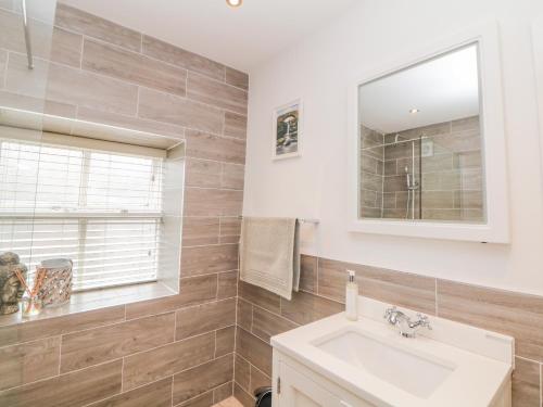 a bathroom with a sink and a mirror at Ardeevin Cottage in Buxton