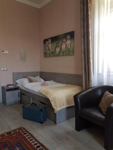 a bedroom with a bed and a chair and a couch at Kétbodonyi Apartments in Kétbodony