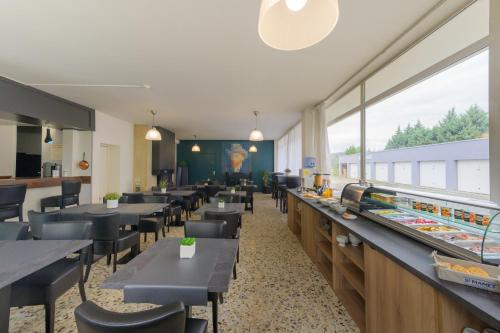 a restaurant with tables and chairs and a buffet at Hôtel Vulcain in LʼHorme