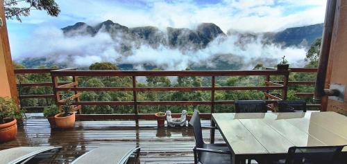 a balcony with a table and a view of a mountain at Cabin in da Woods in Cape Town
