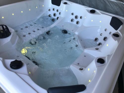 a bath tub filled with water in a sink at Le Hameau du Buron - "Le Petit Buron" - Option SPA in Eyzin-Pinet