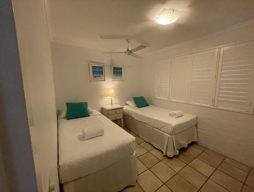 a room with two beds and a lamp at Myuna Holiday Apartments in Noosa Heads
