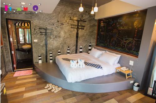 a bedroom with a large bed with two dogs on it at Is Am O Chiang Mai Resort in San Sai