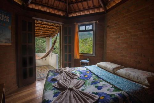a bedroom with a large bed and a window at Hospedagem Sabor Da Trilha in Vale do Capao
