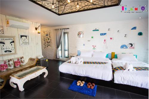 a bedroom with two beds and a bench in it at Is Am O Chiang Mai Resort in San Sai