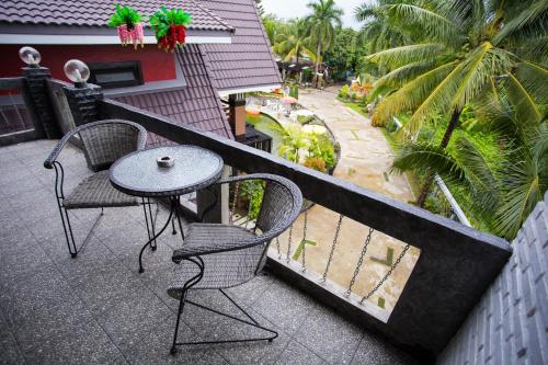 a patio with two chairs and a table on a balcony at Is Am O Chiang Mai Resort in San Sai