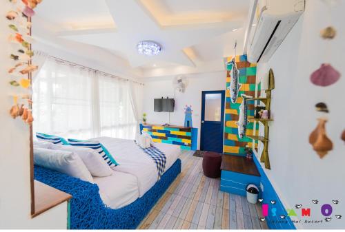 a bedroom with a bed with a blue blanket at Is Am O Chiang Mai Resort in San Sai