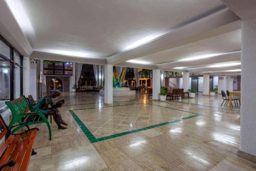 a lobby with green benches and tables in a building at Cozumel Hotel & Resort Trademark Collection by Wyndham in Cozumel