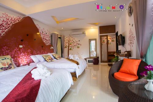 a hotel room with two beds and a chair at Is Am O Chiang Mai Resort in San Sai