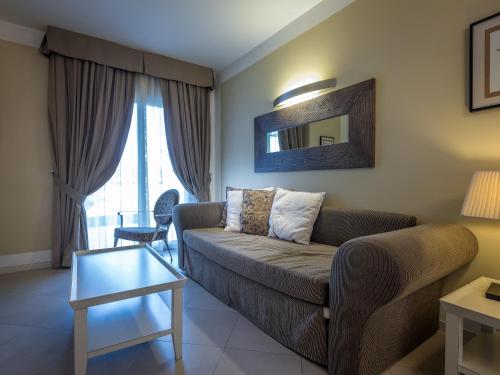 a living room with a couch and a table at Parc Hotel Germano Suites & Apartments in Bardolino
