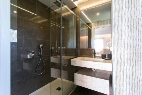 een badkamer met een glazen douche en een wastafel bij Luxury 4 bedr Flat w/ PANORAMIC Views & Pool!! in Algés