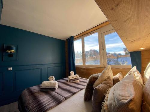 una camera con un letto e una grande finestra di Résidence Les Portes du Soleil - Propriétés Mont Amour ad Avoriaz