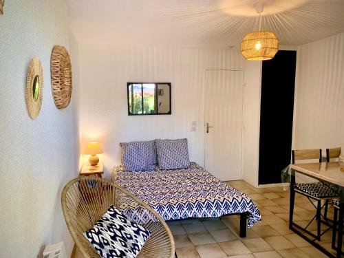 une chambre avec un lit, une table et des chaises dans l'établissement PORTISSOL T1 RDJ CLIM PARKING PRIVATIF 300m PLAGE, à Sanary-sur-Mer