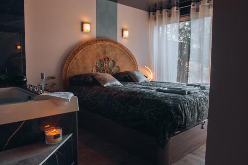 a bedroom with a bed and a sink and a window at La Ronde des Bois - Romance et Bien Être - Jacuzzi privatif-piscine-patio in Mellecey