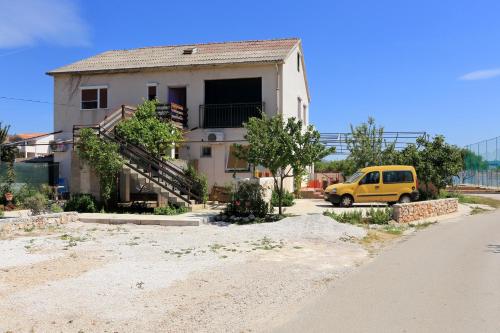 a yellow van parked in front of a house at Basil Apartments and Rooms in Betina