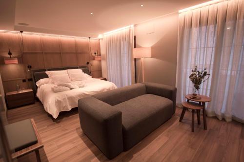 sypialnia z łóżkiem, krzesłem i kanapą w obiekcie Vallivana Suites w mieście Morella