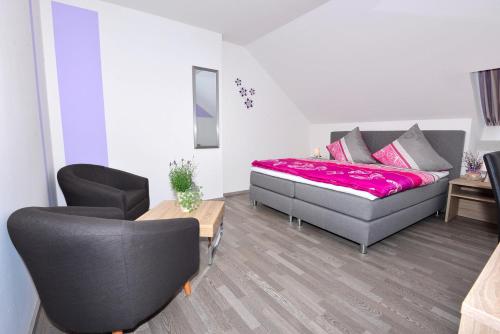 a bedroom with a bed and a table and chairs at Das Arni´s in Mehlmeisel