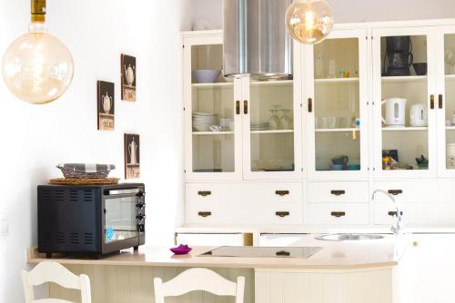 Una cocina con gabinetes blancos y una encimera con microondas. en Villa Opale, en Corralejo