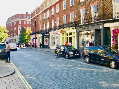 two cars parked on the side of a city street at Victoria Belgravia Apartments in London