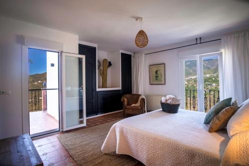 a bedroom with a bed and a balcony at Malaga Hills Double Comfort Boutique & Wellness Eco-Hotel -Adults Only- in Cómpeta