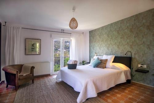 a bedroom with a bed and a chair and a window at Malaga Hills Double Comfort Boutique & Wellness Eco-Hotel -Adults Only- in Cómpeta