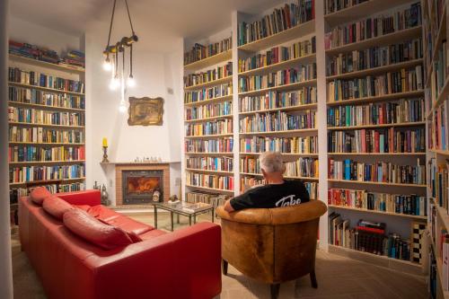 um homem sentado numa cadeira numa biblioteca em Malaga Hills Double Comfort Boutique & Wellness Hotel -Adults Only- em Cómpeta