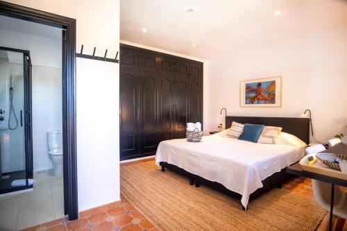 a bedroom with a large bed and a bathroom at Malaga Hills Double Comfort Boutique & Wellness Eco-Hotel -Adults Only- in Cómpeta