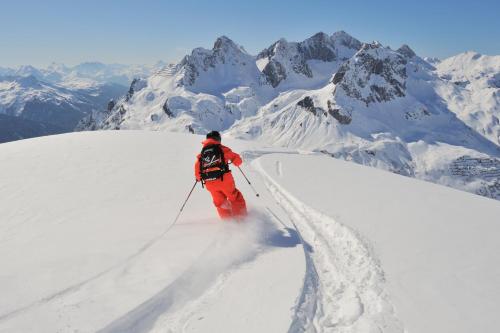 a man is skiing down a snow covered mountain at Kristiania Lech in Lech am Arlberg