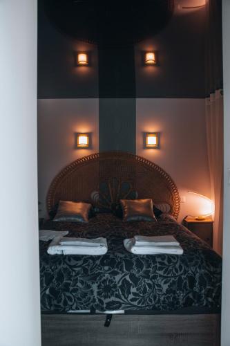a bedroom with a large bed with two pillows at La Ronde des Bois - Romance et Bien Être - Jacuzzi privatif-piscine-patio in Mellecey