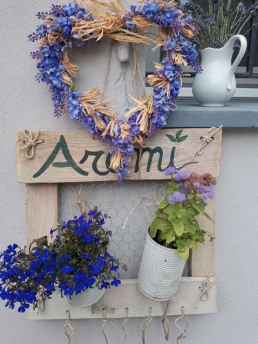 a wreath on a door with a sign and flowers at BB Lady in Castelvetro di Modena