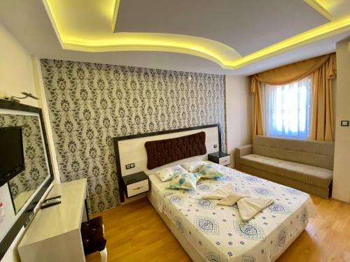 a bedroom with a bed and a couch at Yalcin Hotel & Villas in Oludeniz