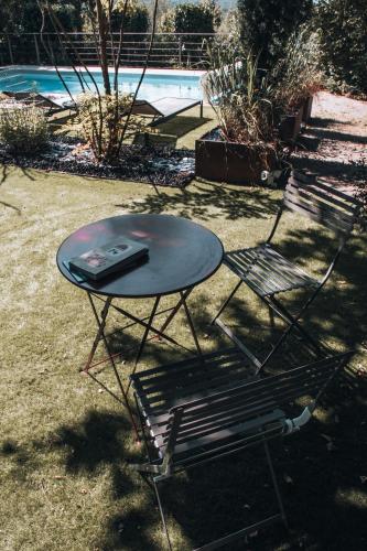 a table and a chair sitting next to a pool at La Ronde des Bois - Romance et Bien Être - Jacuzzi privatif-piscine-patio in Mellecey