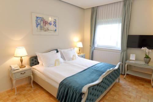 a bedroom with a large bed and a television at ApartHotel Vila Minka in Ljubljana