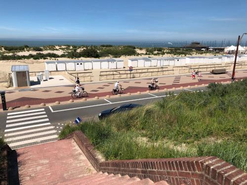 a group of people riding motorcycles on a road near the beach at Luxueus nieuw zonnig hoekappartement SEAVIEW Heldenplein - ruime garagebox - 2 fietsen in Knokke-Heist
