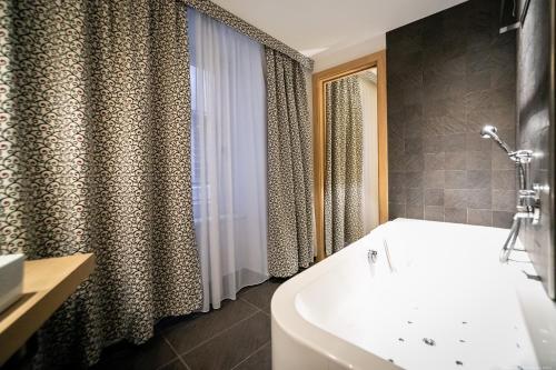 a bathroom with a white tub and a shower at Boutique Exclusive B&B in Trento