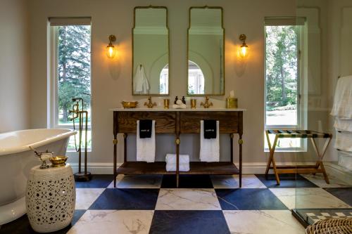 bagno con lavandino, vasca e specchio di Hartford House a Mooi Rivier