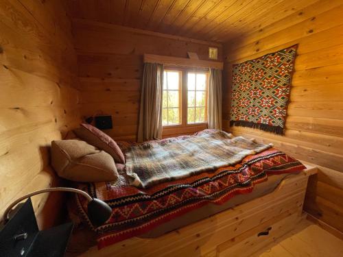 a bedroom with a bed in a log cabin at Bjørnehiet Havsdalen in Geilo