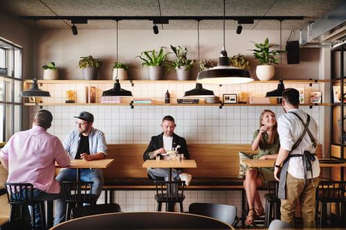 a group of people sitting at tables in a restaurant at Hotel Gilbert in Vienna