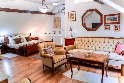 a living room with a bed and a couch and a table at Vila Mila in Arandjelovac