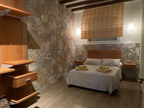 una camera da letto con un letto con due asciugamani sopra di La Masía de Navas a Navas del Pinar