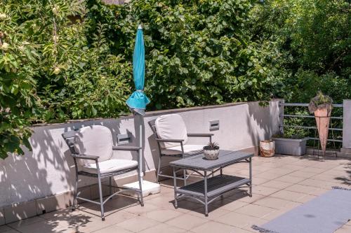 a patio with a table and chairs and an umbrella at Vila Mila in Arandjelovac