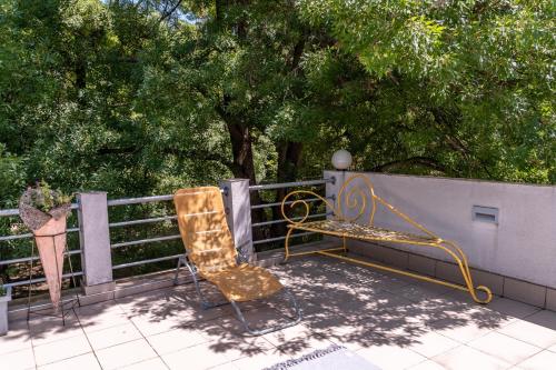two chairs and a bench on a balcony at Vila Mila in Arandjelovac