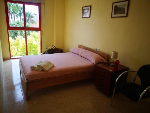 a bedroom with a bed and a table and a window at ROMI CENTRO tu Alojamiento en TEULADA in Teulada