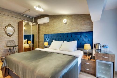 1 dormitorio con 1 cama grande y espejo en Grande Stella Hotel, en Eskisehir